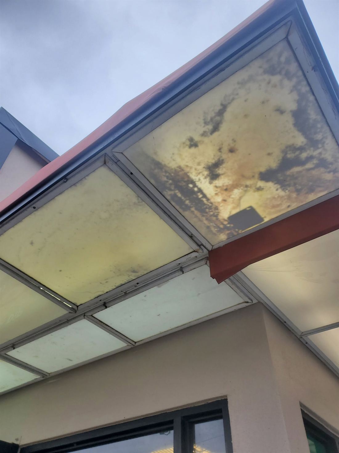 Storefront canopy before — yellowed and stained